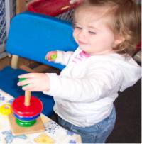 Toddler playing with manipulatives – wooden peg board